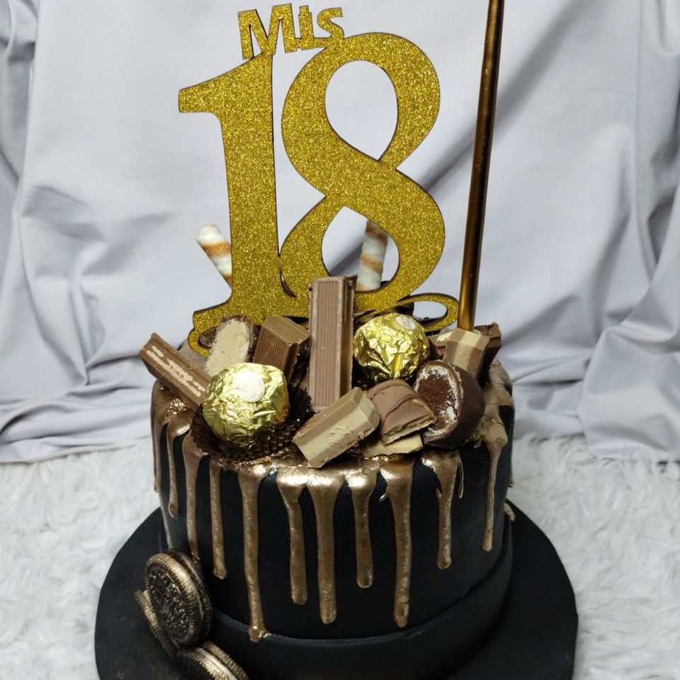 Torta de 18 años negra con chorreado dorado, bombones y cartel «Mis 18»