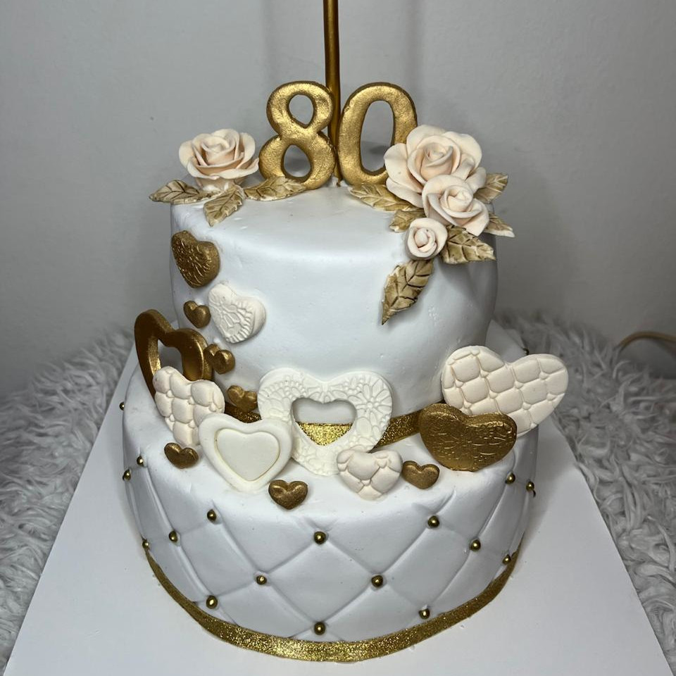 Torta de 80 años de dos pisos en fondant blanco con rosas y detalles dorados