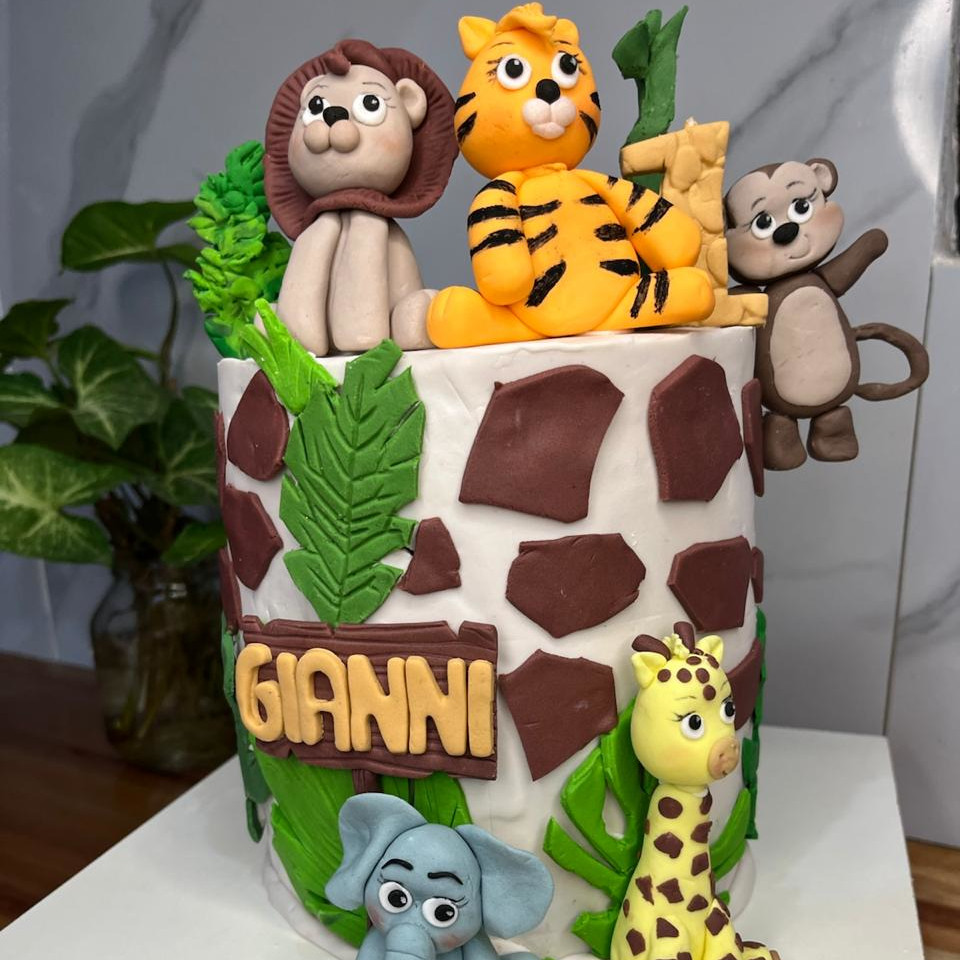 Torta infantil de animales de la selva con león, tigre, jirafa y elefante en fondant