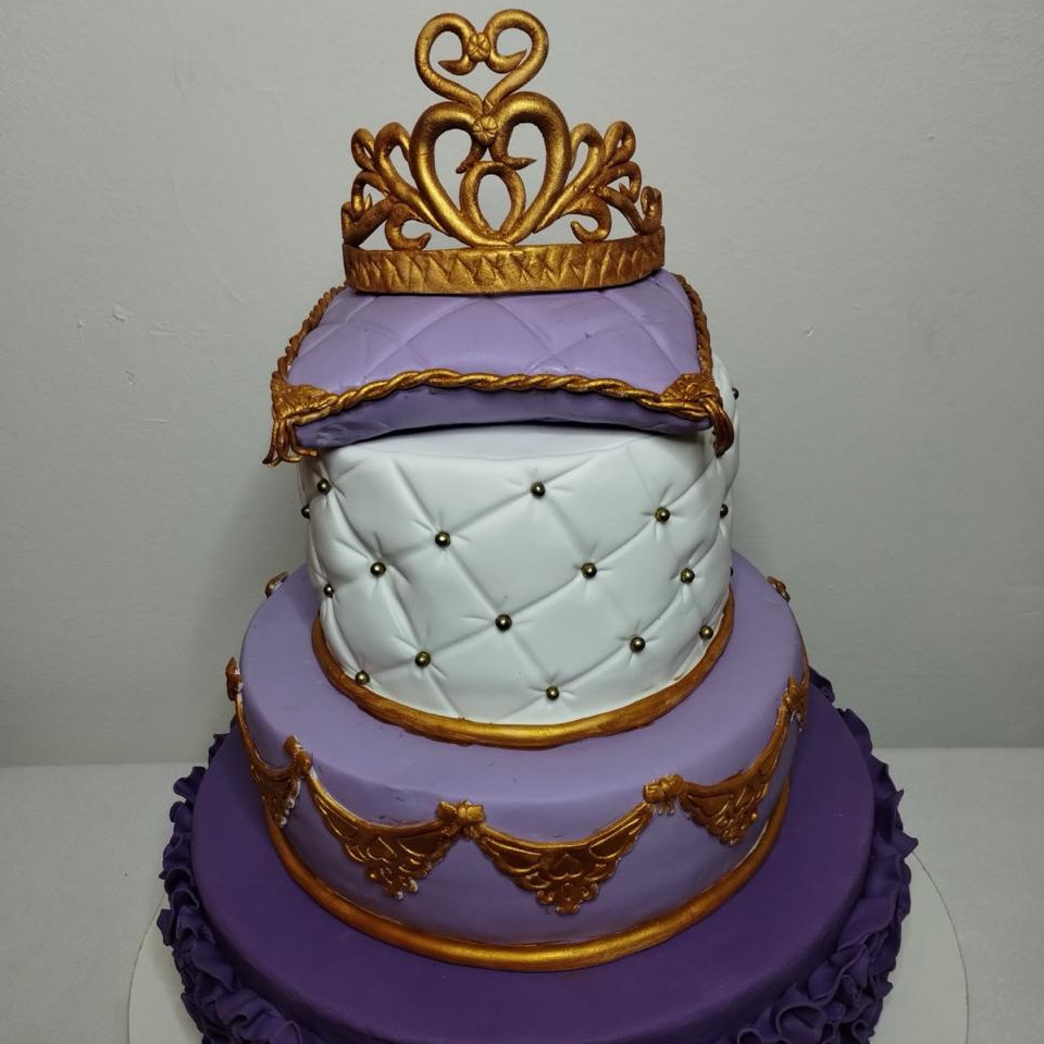 Torta de tres pisos en lila y blanco con corona dorada y guardas doradas